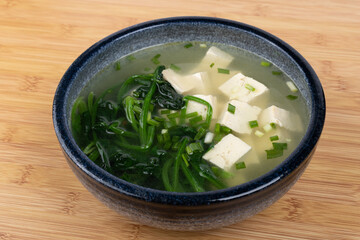 Spinach and tofu soup in a porcelain bowl