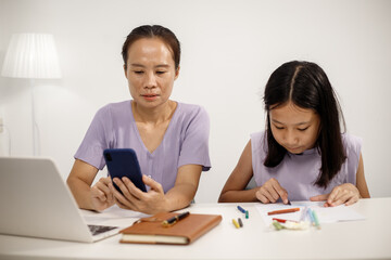 Asian mother spends warm, loving moments with her 10-year-old daughter in cozy room, highlighting family bonding, emotional connection, care, support, beauty of unconditional love and togetherness.