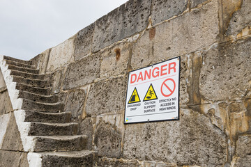 Danger Sign on Stone Harbour Steps at The Cobb, Lyme Regis, Dorset, England