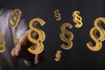 Abstract image of golden paragraph symbols hovering near a hand, ideal for legal or law concepts.