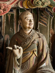 Clay sculpture of Budhist monk at historical Guanyin Hall in Liangjiazhuang Village, Changzhi, Shanxi, China, known for extraordinary Ming Dynasty suspended sculptures. National heritage.
