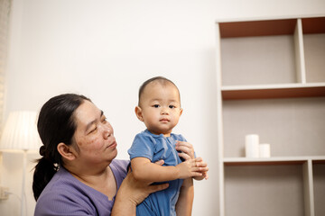 An overweight Asian woman brings her one-year-old son to consult a health expert in a private office. The scene emphasizes family care, professional guidance, wellness improvement