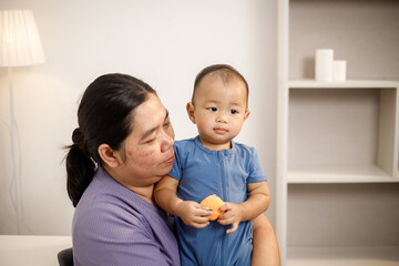An overweight Asian woman brings her one-year-old son to consult a health expert in a private office. The scene emphasizes family care, professional guidance, wellness improvement