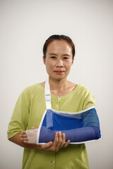 A person from the chest up wears a light green cardigan over a white shirt, with their right...
