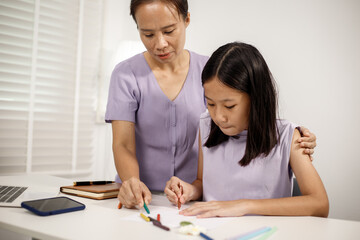Asian mother spends warm, loving moments with her 10-year-old daughter in cozy room, highlighting family bonding, emotional connection, care, support, beauty of unconditional love and togetherness.