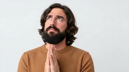 A bearded man with long hair is praying with his hands clasped together, eyes closed, seeking hope, faith, and spiritual guidance on white background