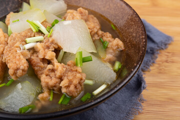 The winter melon and meat soup dish in a porcelain bowl