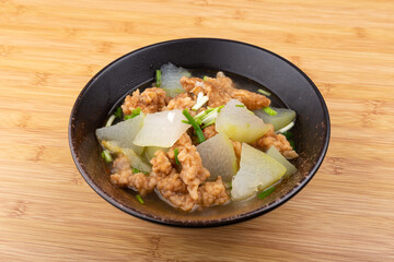 The winter melon and meat soup dish in a porcelain bowl