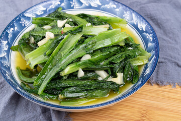 The vegetarian stir-fried romaine lettuce on a white plate of Sichuan cuisine