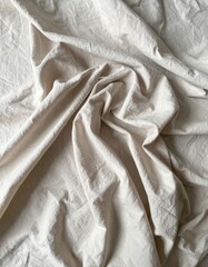 Beige Fabric Texture Background with Crumpled Folds in a Soft Neutral Tone