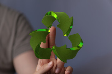 Eco-friendly concept image.  Person interacts with a 3D recycling symbol.