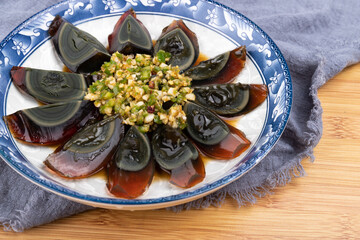 The cold mixed preserved eggs with pine flowers on the plate