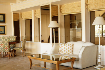 Luxury living room interior. Cream sofa, glass coffee table, floor lamp, and elegant decor.