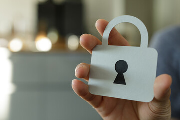 Image of a hand holding a paper cutout of a lock, symbolizing data protection and security.