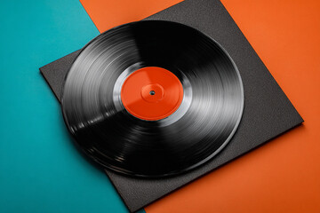 Fototapeta premium Black vinyl record on colorful background orange teal music album