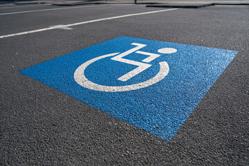 Accessible parking space blue paint wheelchair symbol asphalt