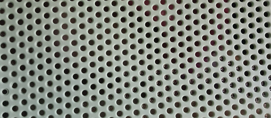 Metal perforated surface with round holes as industrial texture background