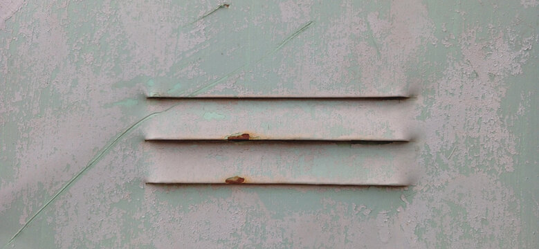 Vintage rusty vent grille on old painted wall