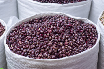 Large sacks filled with speckled red beans at a market