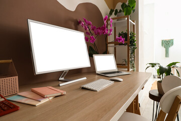 Workplace with computer, laptop and orchid flower in stylish office