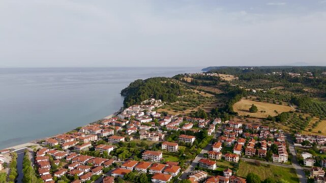 Aerial Drone Circle Shot of Siviri Village and Beach in Kassandra, Halkidiki, Greece on a Bright Summer Day.