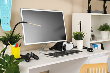 Teenager's workplace with modern gadgets and plants in room