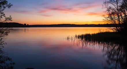 Fototapeta premium 静かな湖面に映る、穏やかな夕焼け空。美しい色彩とシルエットが調和。. AI Generated