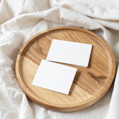 Two Stacked Business Cards on a Light Brown Wooden Plate with White Cloth