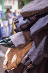 Stack of second-hand suit jackets displayed at a market stall