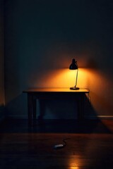 A dimly lit room, a single unplugged lamp on a table, casting a small pool of light in the otherwise dark space The power cord lies detached, symbolizing disconnection and absence , broken, light