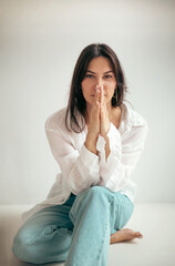 Fototapeta premium Young woman sitting in studio in thoughtful mood. Character of woman
