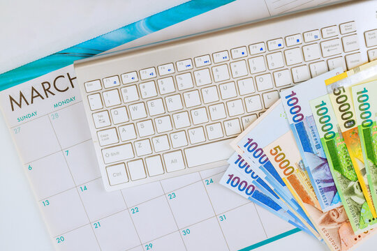 South Korean won cash lies next to calendar keyboard, indicating monthly budgeting activities in March.