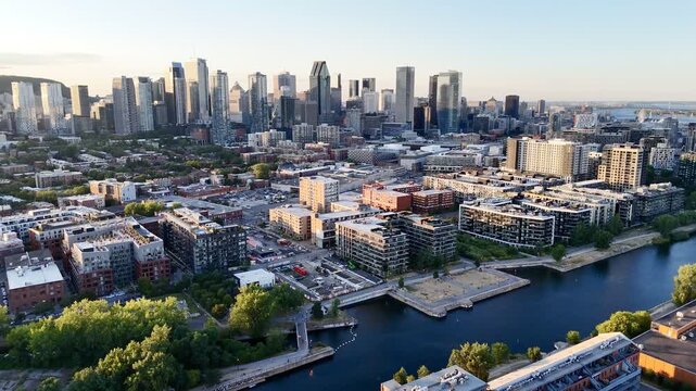 Aerial view of modern waterfront district with high-rise buildings and riverside paths, Montreal twilight skyline. g.