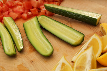 Sliced Cucumber, Lemons, and Tomatoes on Wooden Cutting Board