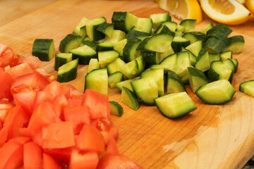 Sliced Cucumber, Lemons, and Tomatoes on Wooden Cutting Board