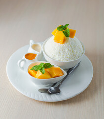 Refreshing Mango Bingsu, a Korean shaved ice dessert with fresh mango cubes, mint, condensed milk,...