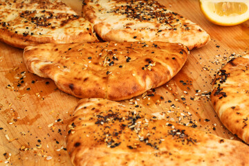 Fresh Pita Bread on Wooden Cutting Board with Olive Oil and Seasoning