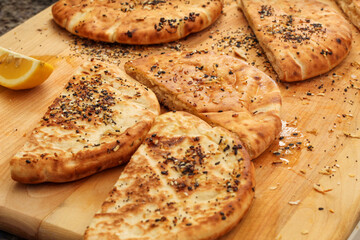 Fresh Pita Bread on Wooden Cutting Board with Olive Oil and Seasoning