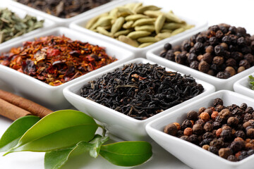 Fototapeta premium Assorted teas and spices in small white bowls with cinnamon sticks and leaves