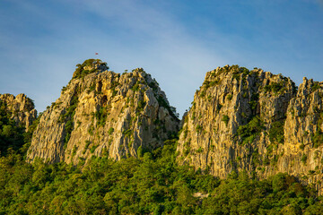 The sun's golden light streams down on the mountains in the middle of rice fields in the evening.