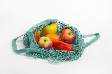 Top view of mesh green shopping bag with organic vegetables isolated on white background