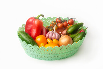 Fresh organic vegetables and fruits in plastic basket. Close-up of assorted fresh vegetables isolated on white background. Healthy food. Harvesting in autumn
