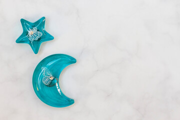 Blue Resin Moon and Star Fridge Magnet with Embedded White Butterflies on Marble Background