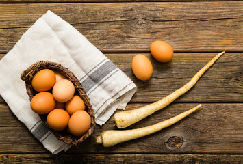 basket of eggs and parsley roots, old weathered wooden background