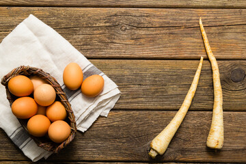 basket of eggs and parsley roots, old weathered wooden background