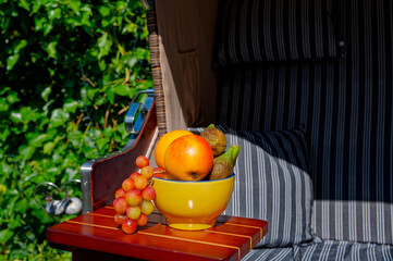 Bowl with various fruits on the table of a beach chair.