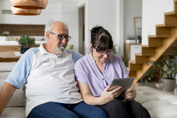 Happy senior couple enjoying tablet time together