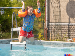 Junge hat Spaß im Pool mit Springen, Tauchen und Spritzen