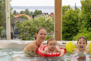 Familie badet im Whirlpool mit Blick auf den Vätternsee, Schweden