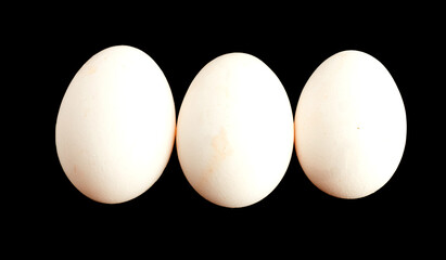 Three eggs isolated on black background

